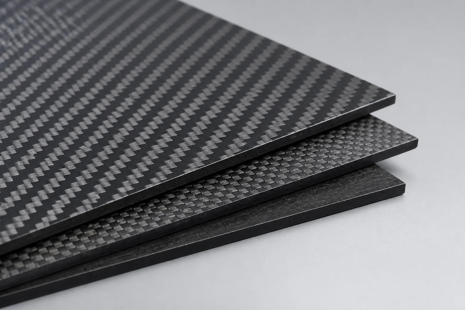 Illustrative close view of layered carbon fiber sheets with distinct woven face patterns